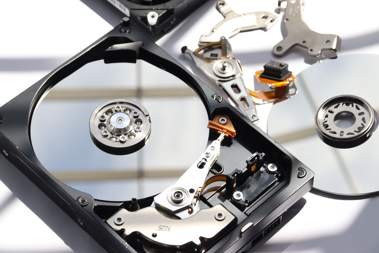 Home Detailed view of disassembled HDD showing intricate internal components.